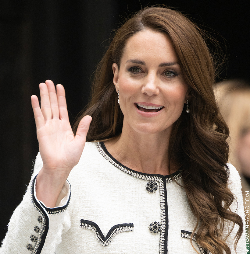 The Princess of Wales, wearing a white and black jacket, waves at the camera.