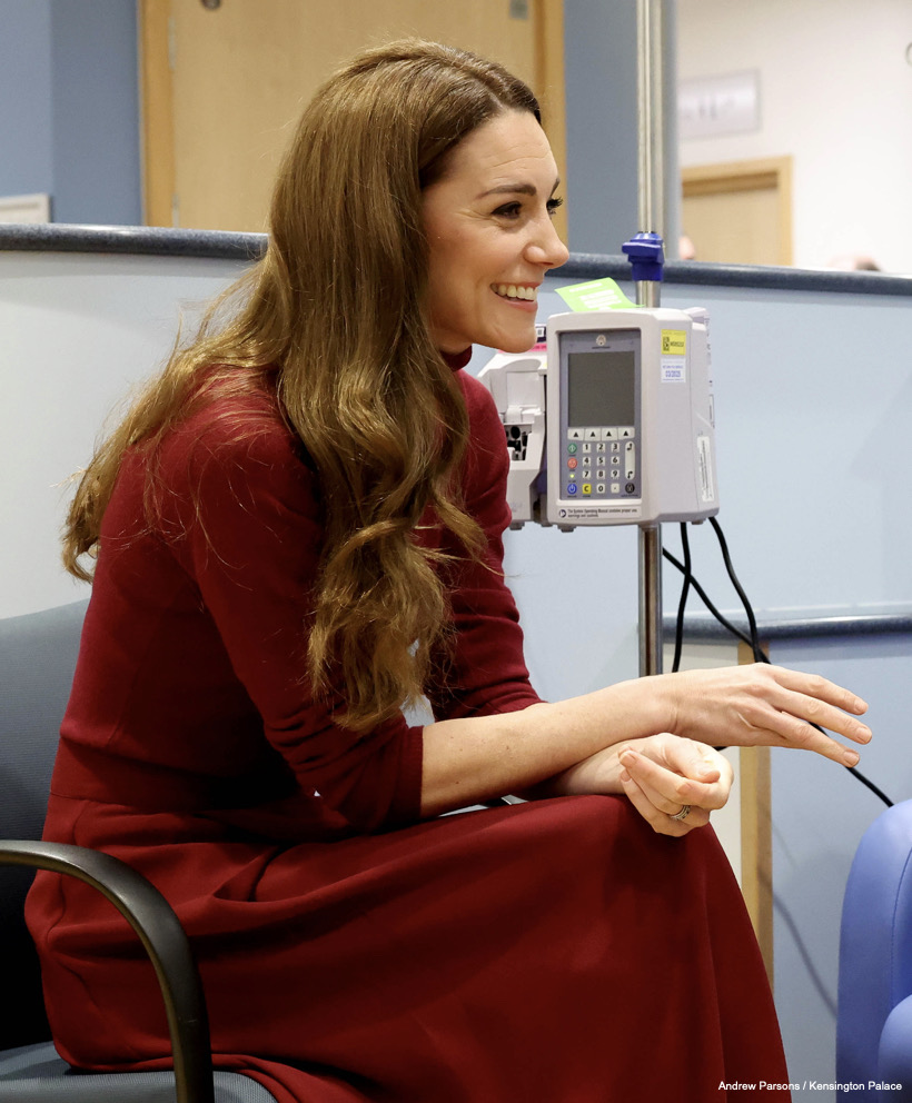 Kate Middleton in a red jumper and skirt chatting to a patient during her visit to the Royal Marsden in January 2025