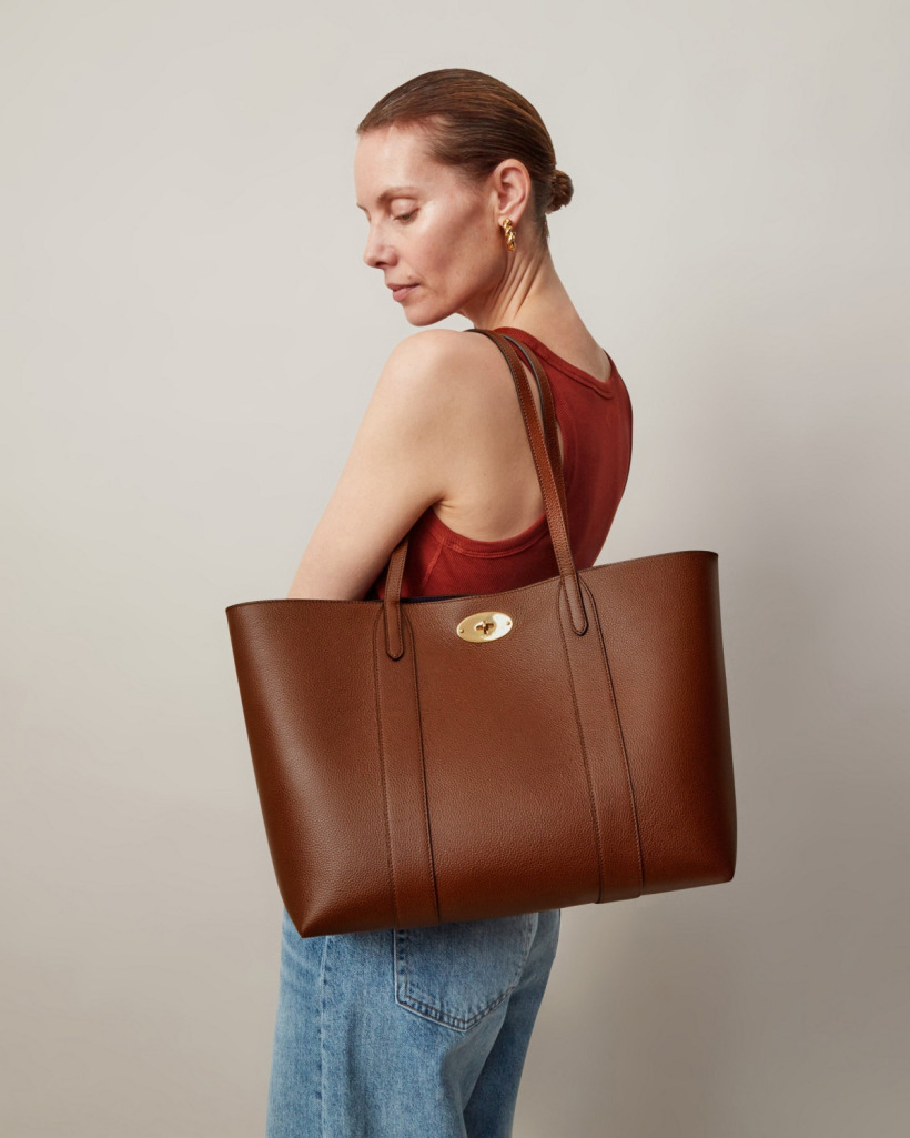 A model holding the Mulberry Bayswater Tote, demonstrating its size and versatility as a shoulder or arm-carry bag.