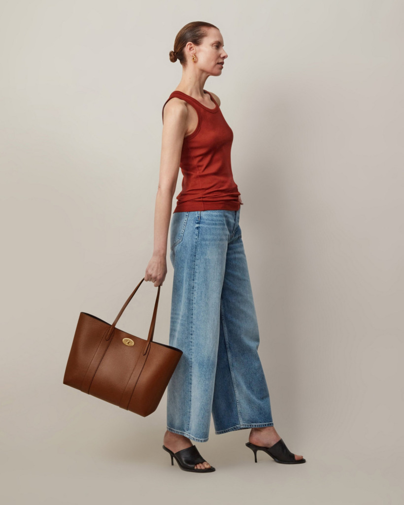 A model holding the Mulberry Bayswater Tote, demonstrating its size and versatility as a shoulder or arm-carry bag.