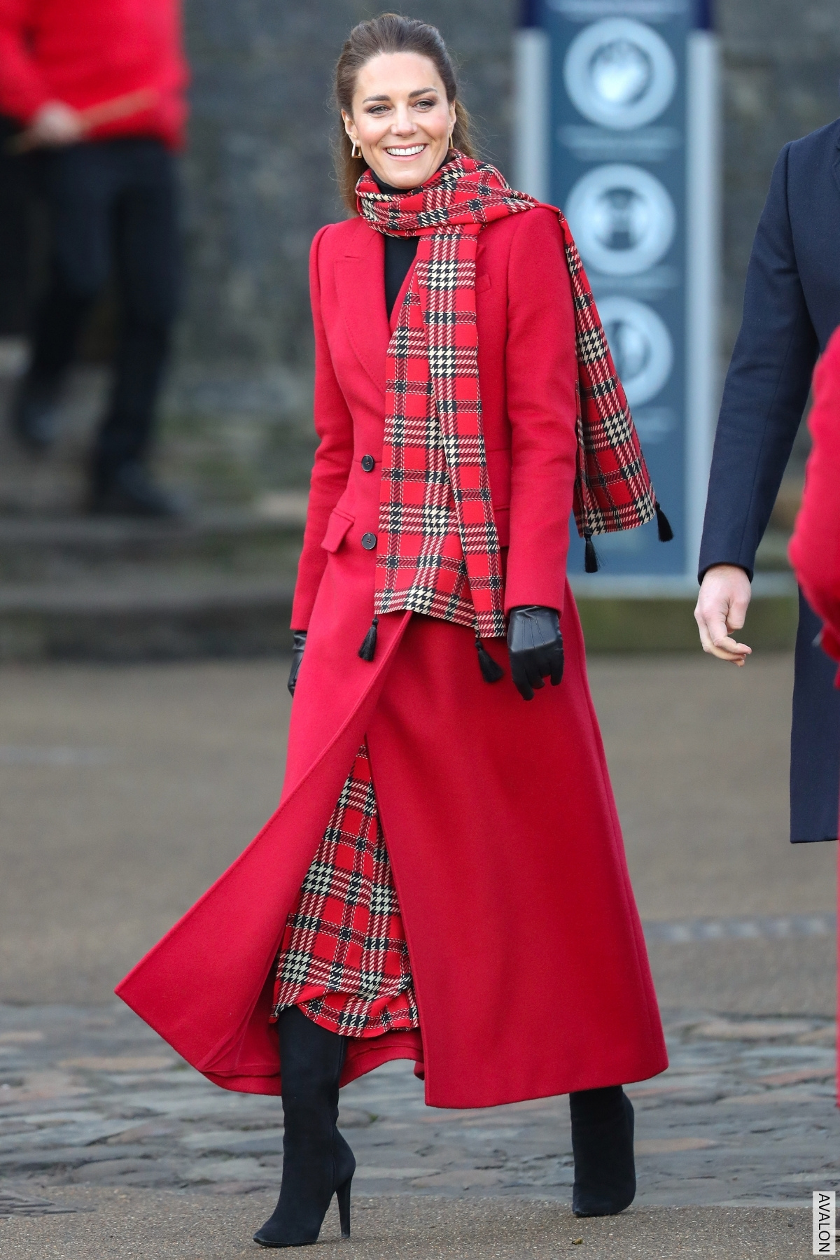 The Princess of Wales wearing a red coat, tartan scarf and matching tartan skirt