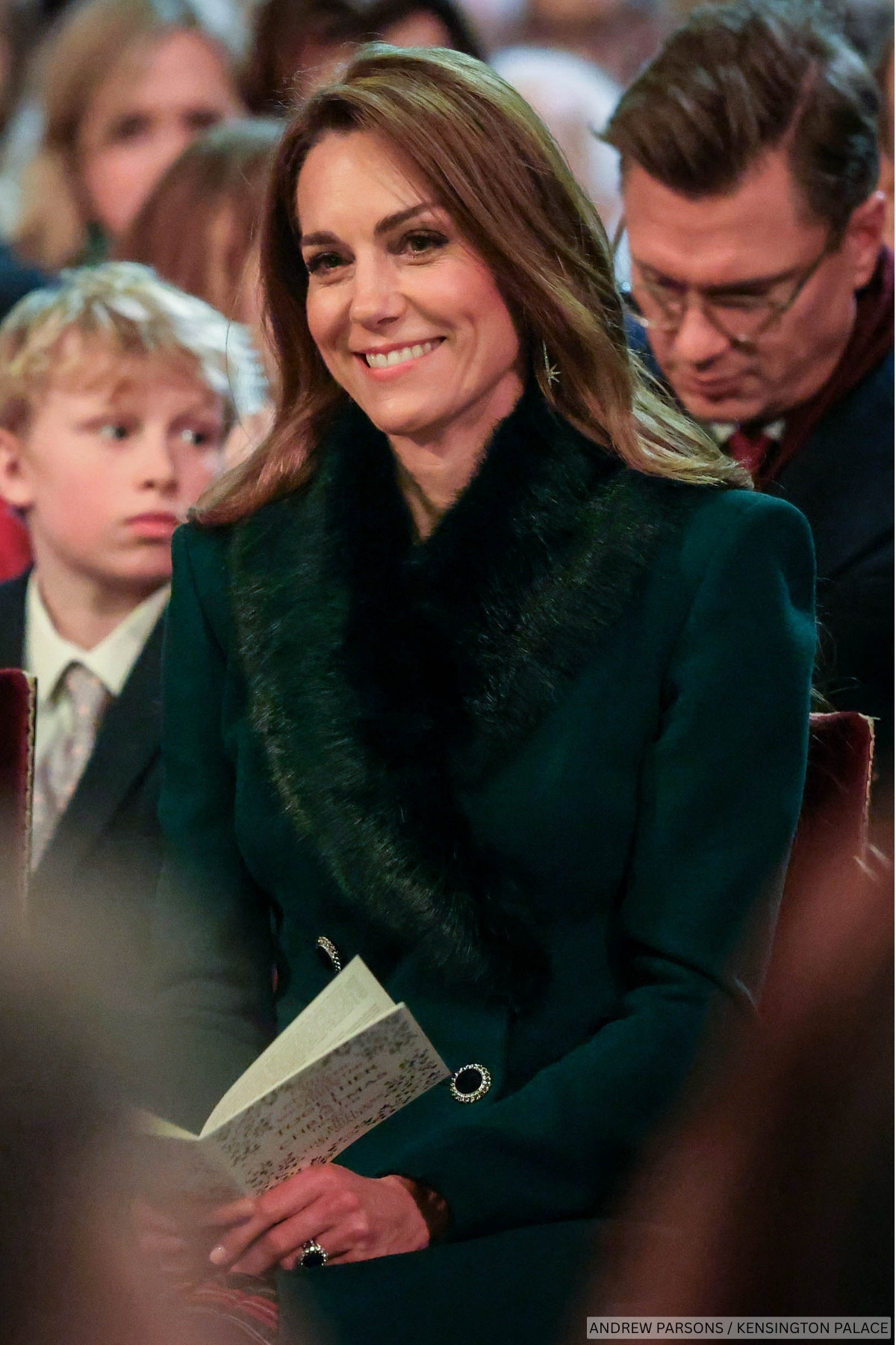 The Princess of Wales is smiling, wrapped up in a green winter coat