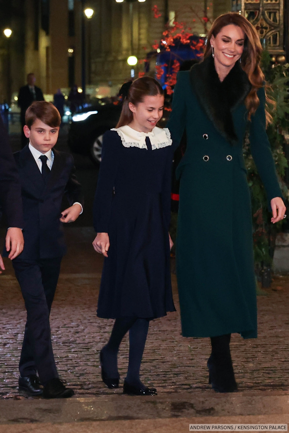 Ther Princess of Wales walks with her children into Westminster Abbey, for the 2025 Together At Christmas carol concert, all wearing coordinating green and navy looks.
