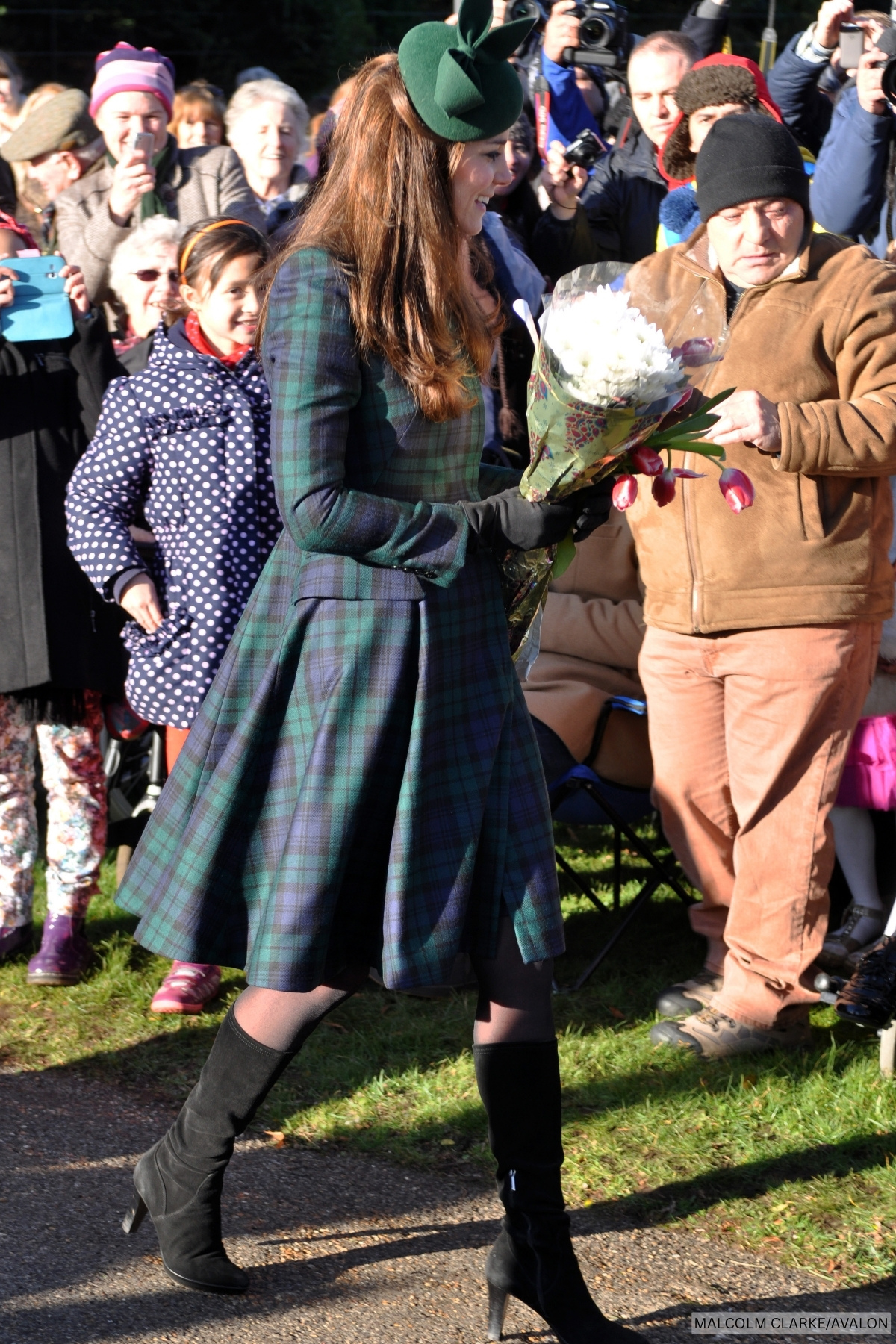 The Princess of Wales at Sandringham chatting to well-wishers on Christmas Day, she wears a blue and green blackwatch tartan dress.