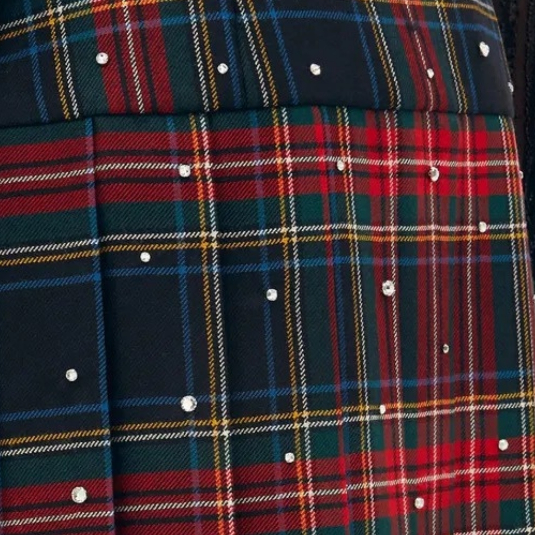 Close-up product image of the red plaid skirt by Miu Miu, showing the design and crystal embellishments. 