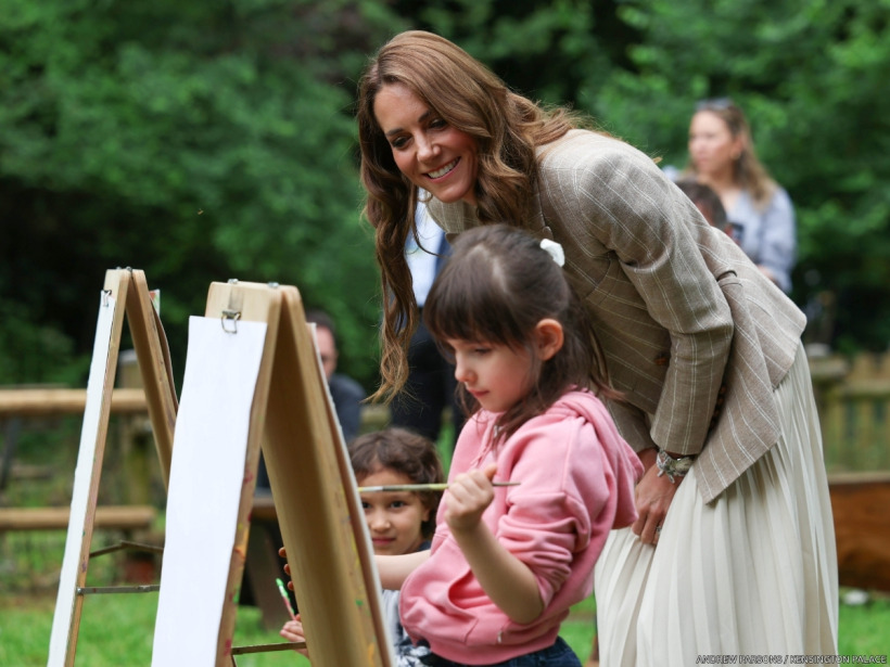 Kate Middleton in her beige pinstripe blazer and ivory pleated skirt at a Reggio Emilia engagement.