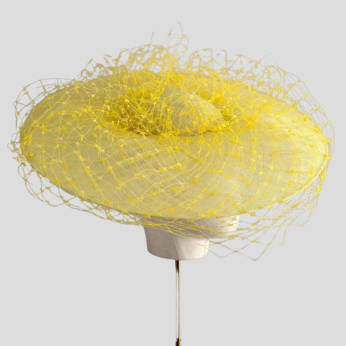 The Jane Taylor 'Epona' hat in yellow with a wide downturned brim and dramatic veiling