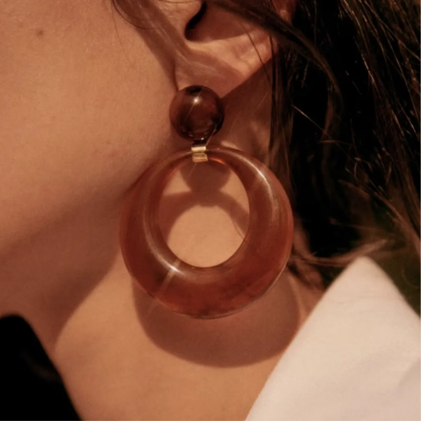 Close-up of the Sézane 'Gabrielle' earrings with an oversized brown resin hoop