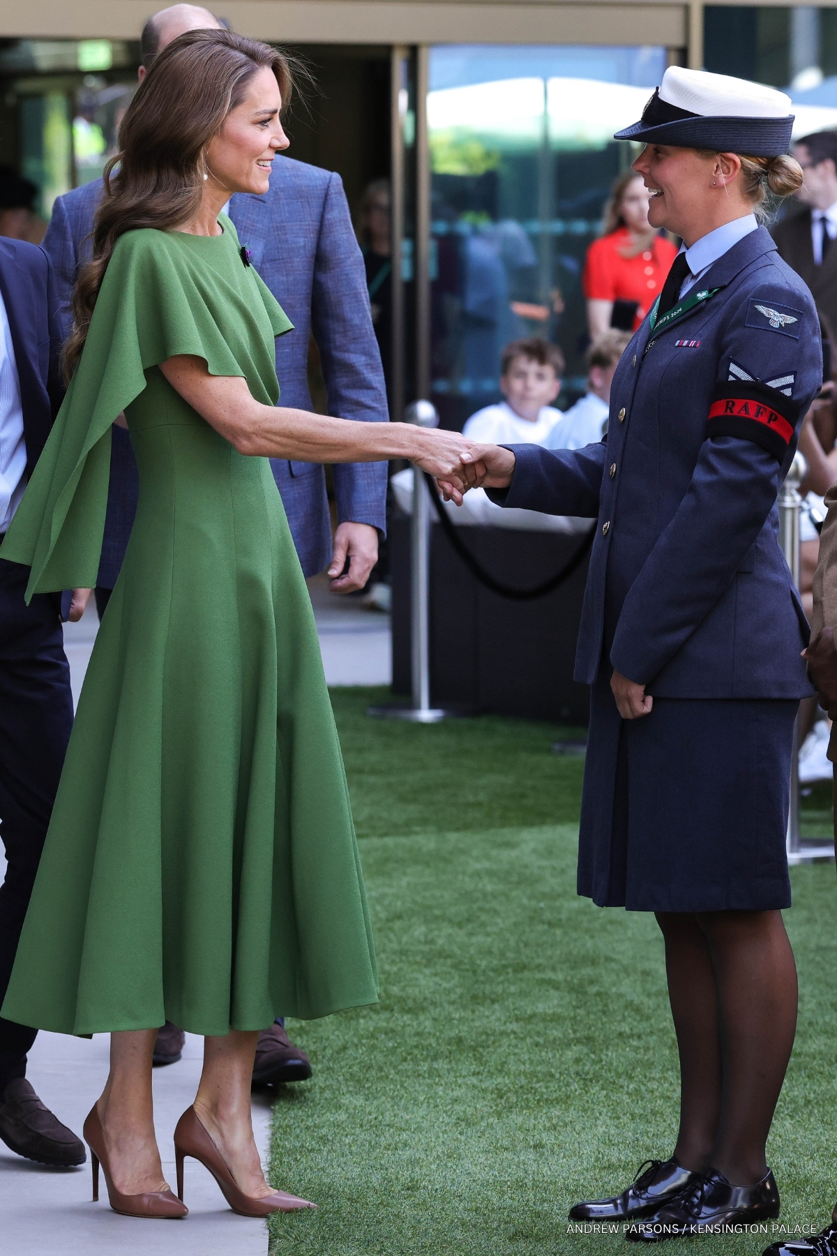 Kate Middleton in her olive green cape dress during a meet and greet at the All England Club