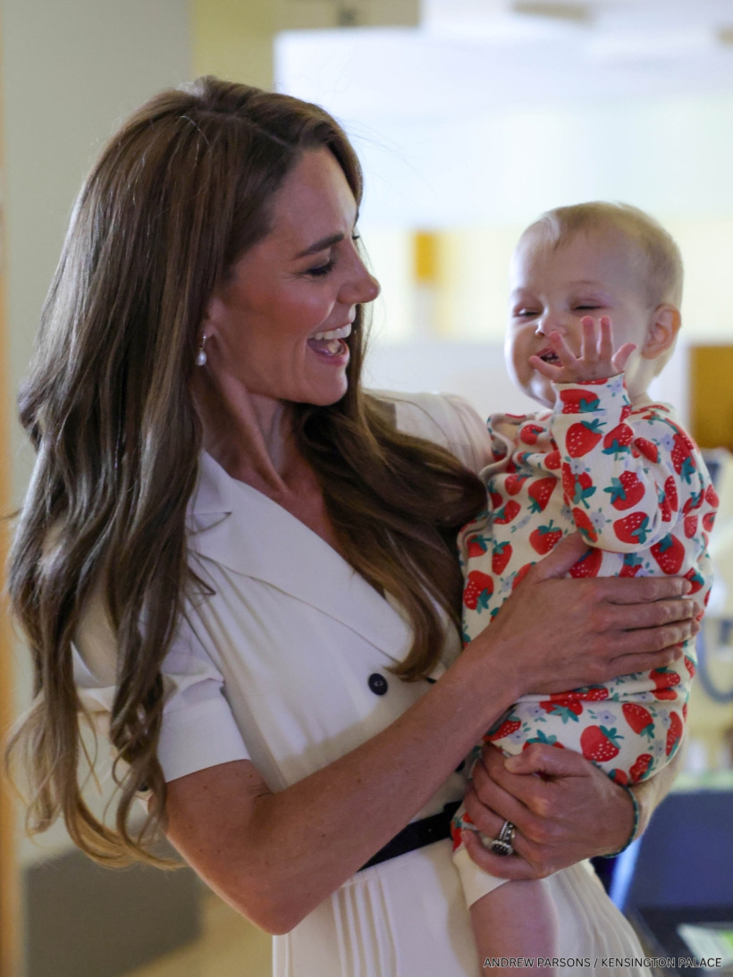 The Princess of Wales in a white Suzannah London dress as she tours Evelina London Children's Hospital, and meets a young baby