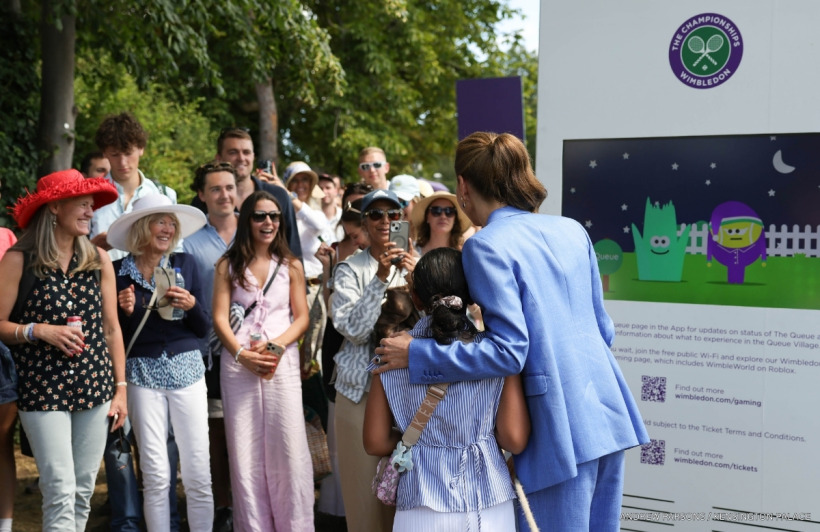 Kate Middleton posing for a photo with a young fan at Wimbledon