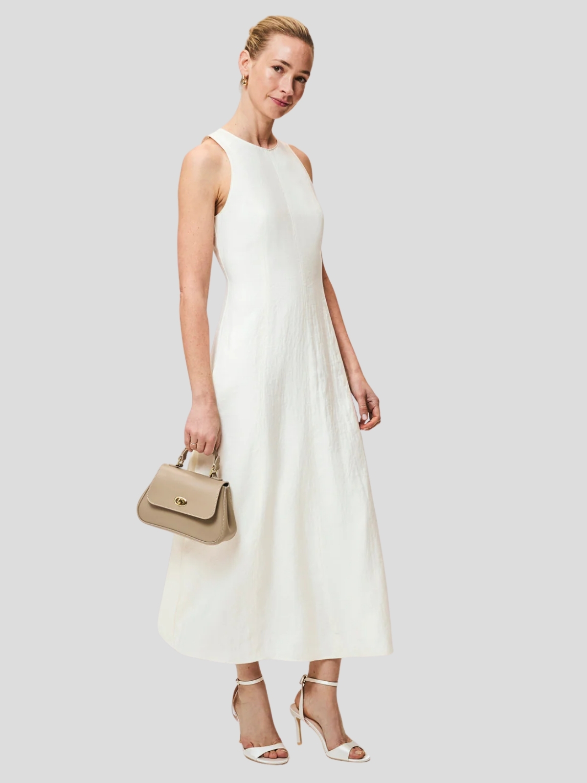 A model carrying the Tusting Mini Holly bag by its top handle