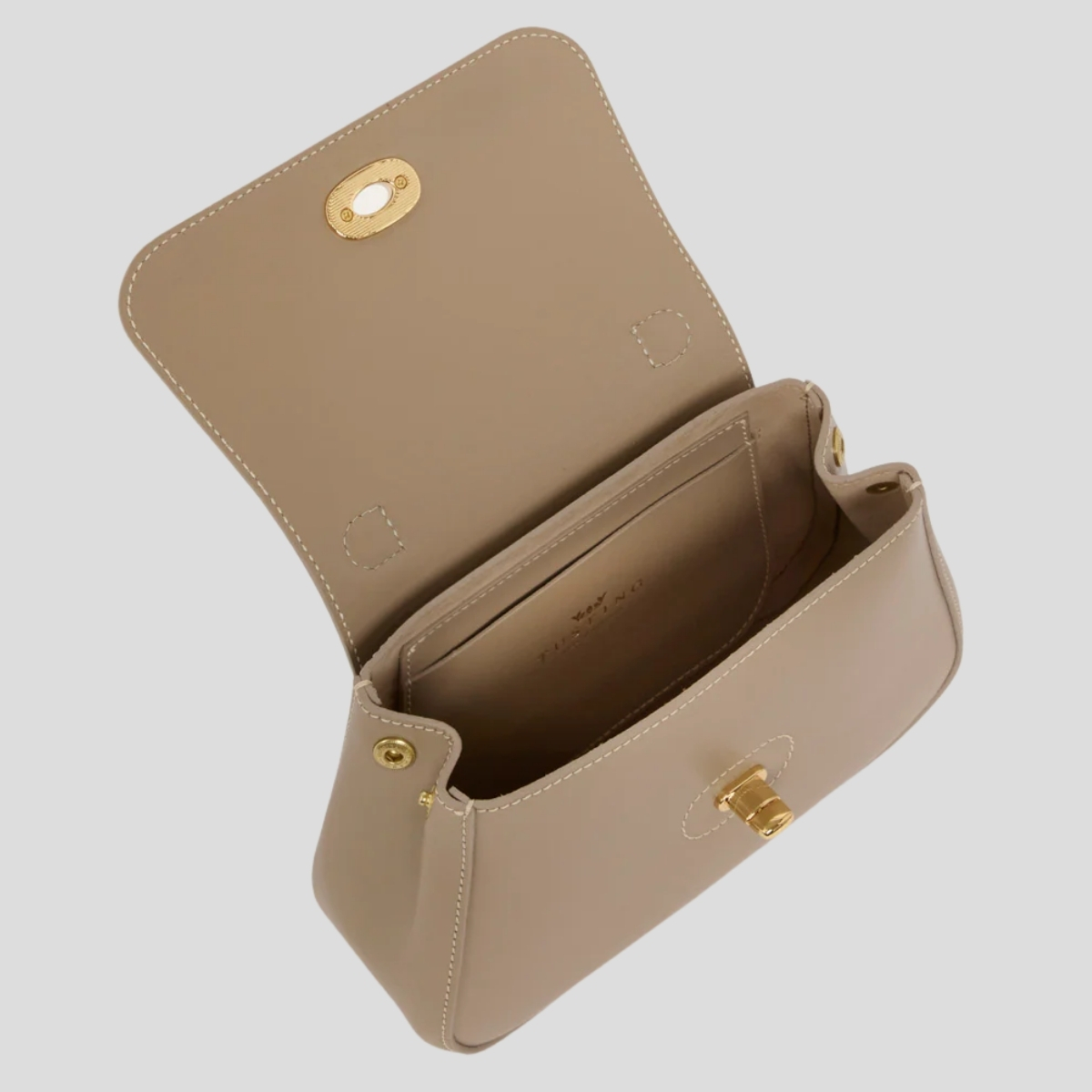 The Tusting Mini Holly bag in taupe shown open, revealing the suede lining and internal slip pocket
