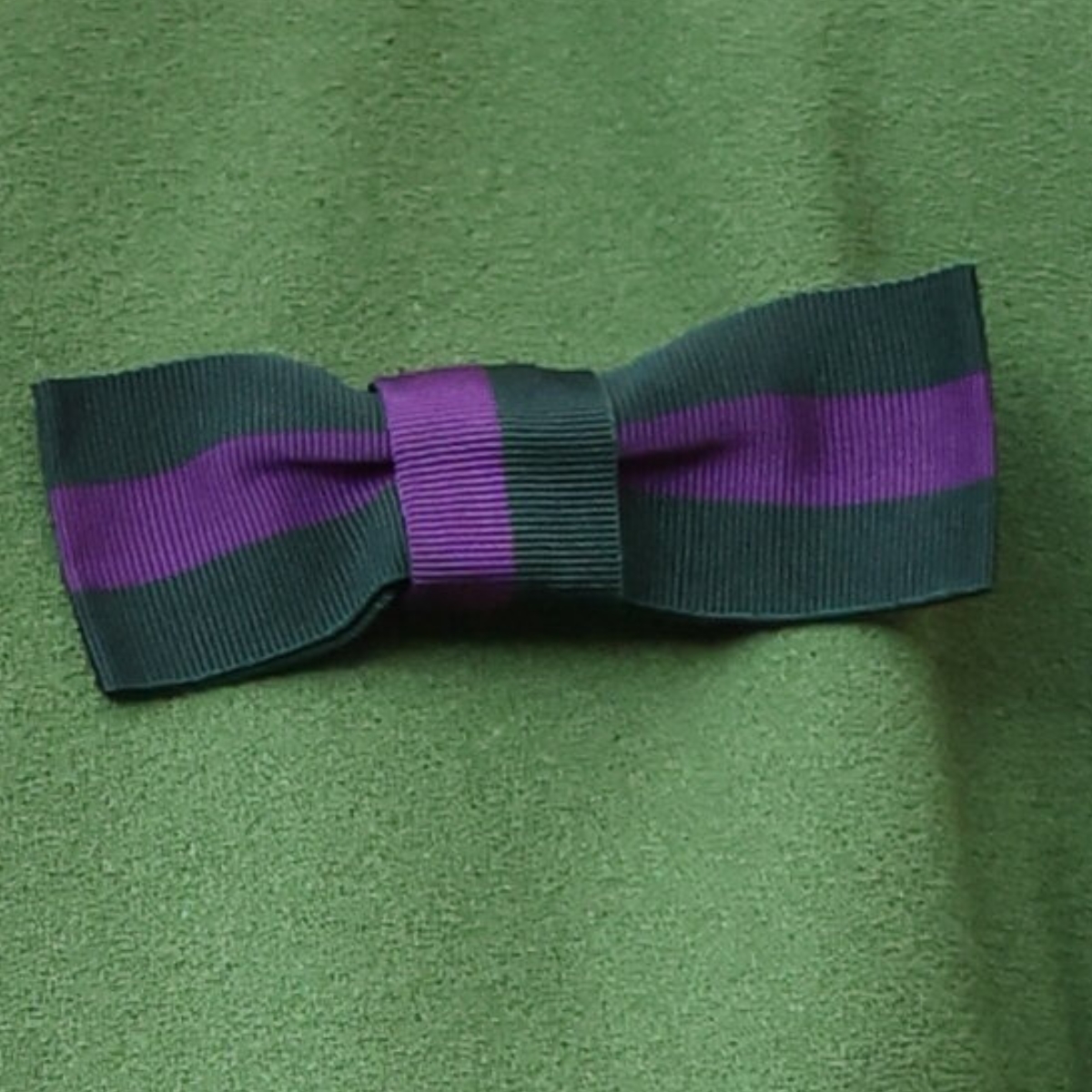 The green and purple All England Club ribbon bow pinned at Kate Middleton's shoulder