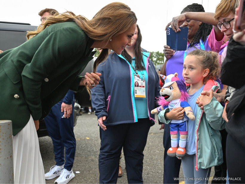 Kate Middleton talking to a girl holding a soft toy of the unicorn mascot