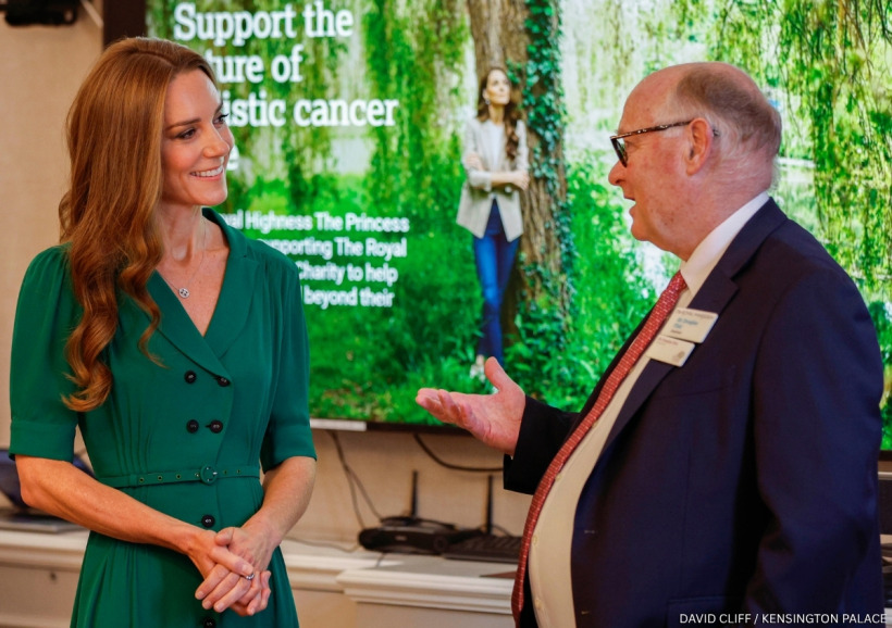 Kate Middleton in a green dress speaking with staff during her visit to The Royal Marsden Hospital