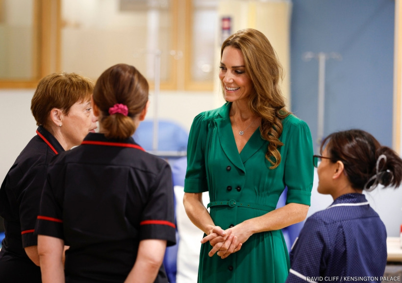 Kate Middleton smiling while touring The Royal Marsden Hospital in her emerald green dress
